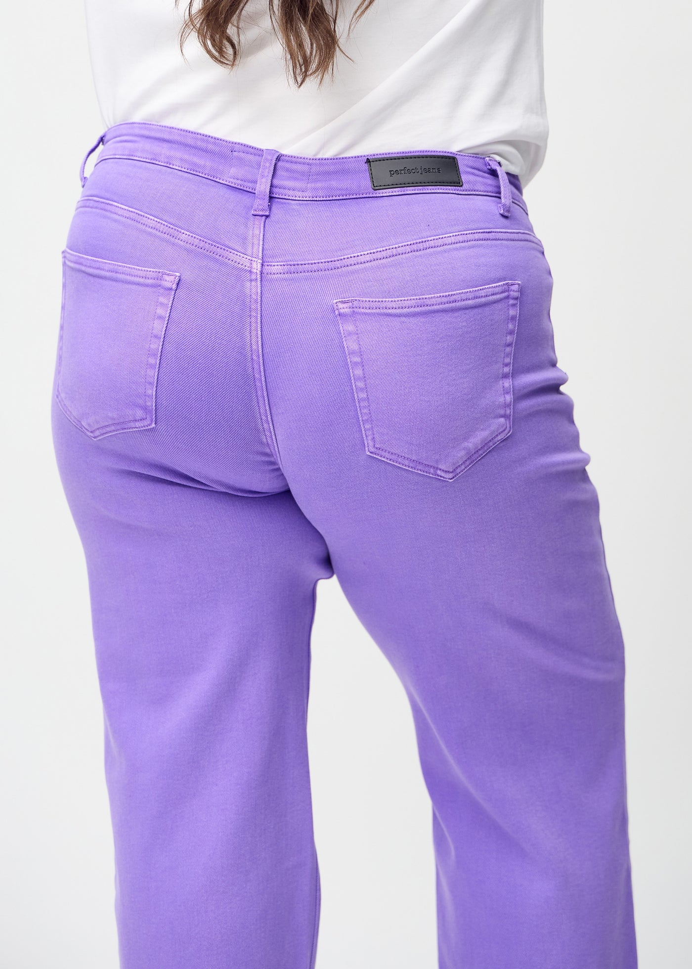 Lilla loose jeans set bagfra tæt på en plus-size model for at vise detaljer.