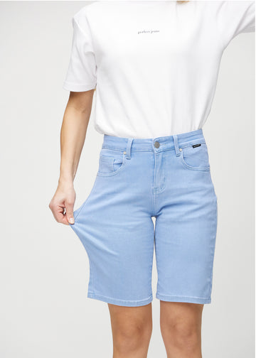 Model strækker shortsene ved låret for at vise stretch.