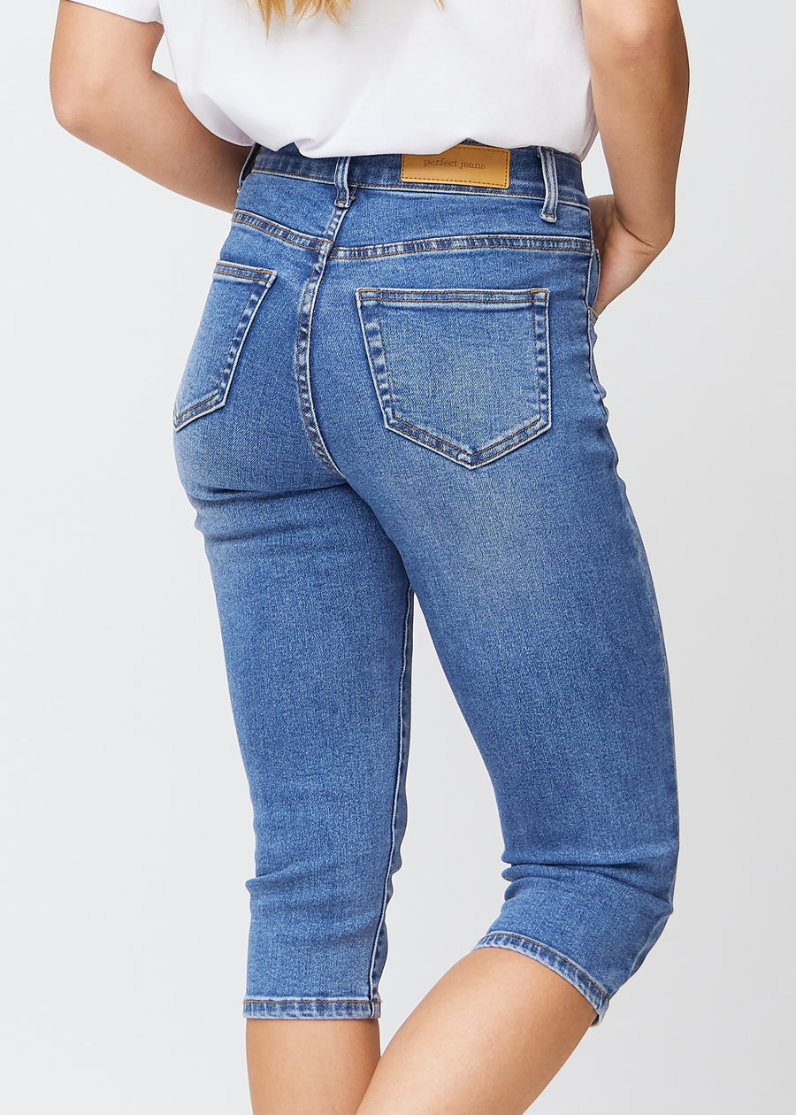 Tæt billede af de blå denim slim capris bagfra, så man tydeligt kan se detaljer og lommer.