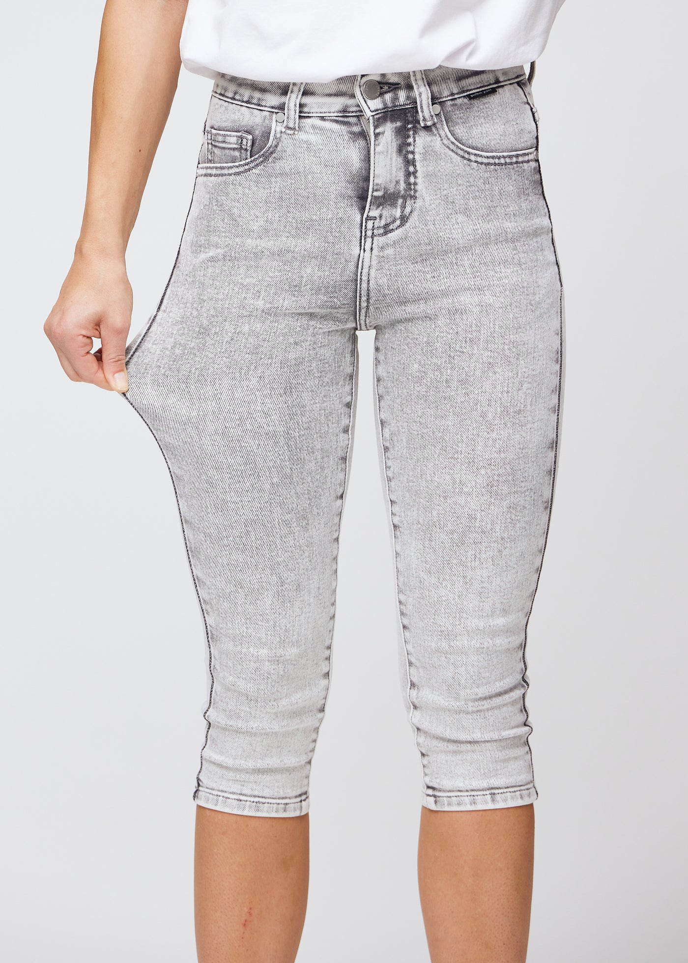 Model strækker caprisene ved låret for at vise stretch.