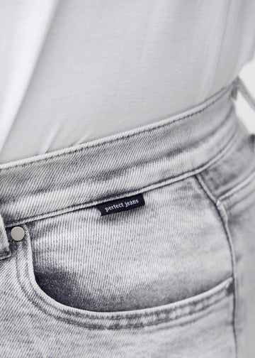 Forlommen på et par lysegrå denim middle shorts, hvor man kan se logoet.