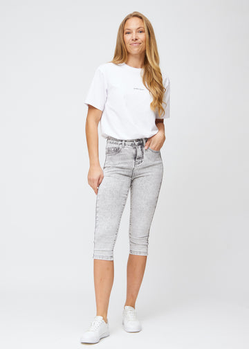 Fuldt billede af model i lysegrå denim skinny capris.