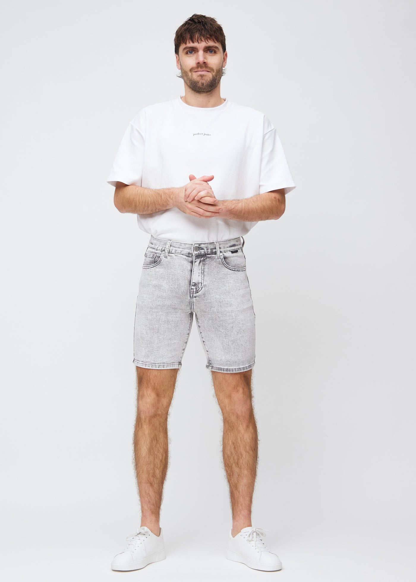 Fuldt billede af model i lysegrå denim regular middle shorts.