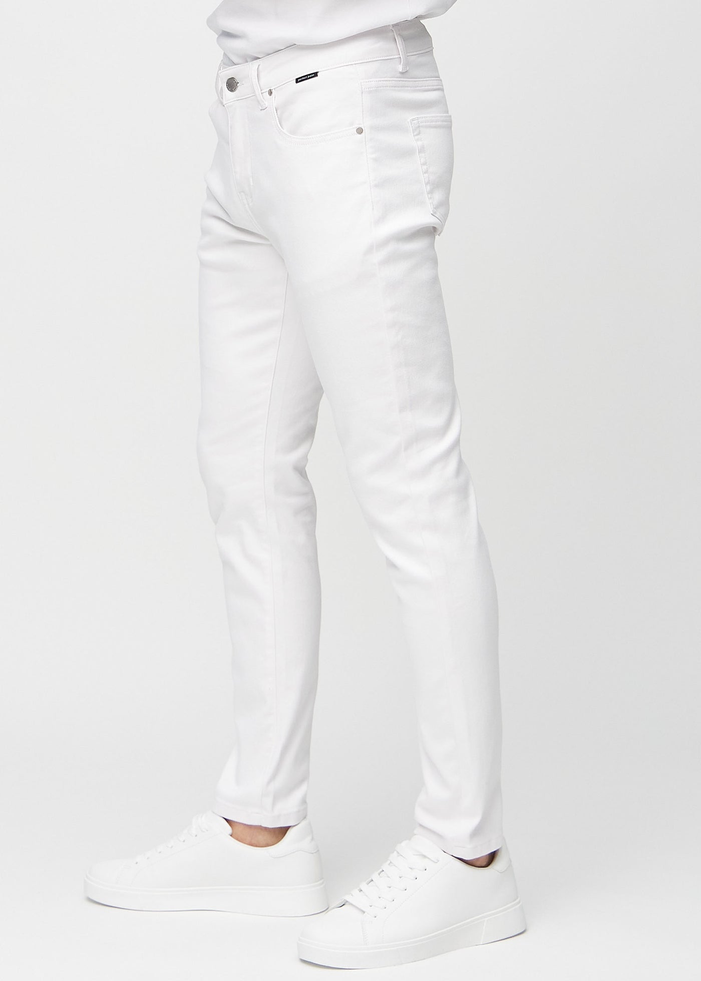 Hvide slim jeans set fra siden på model.