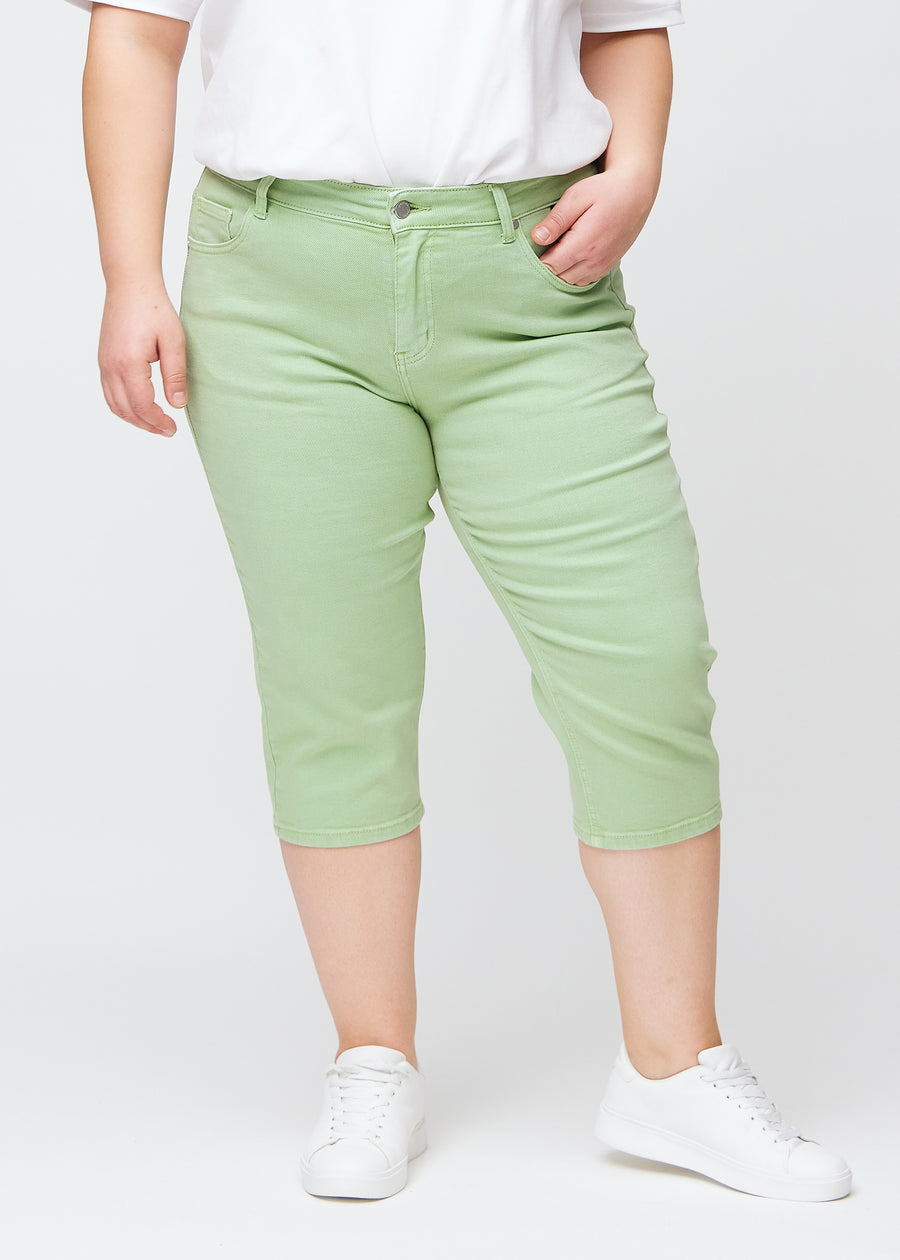 Lysegrønne slim capris, farve Mints, med tætsiddende pasform og længde lige under knæet – set forfra på plus-size model.