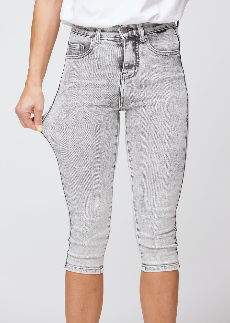 Model strækker caprisene ved låret for at vise stretch.