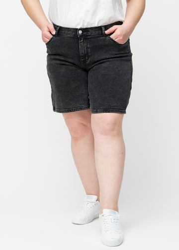 Løse, mørkegrå denim shorts i farven Shadows set forfra på plus-size model, der sidder til ved hoften og falder løst ned.