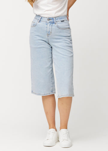 Loose, light blue Waves denim capris that sit close at the hips and fall loosely over the thighs to just below the knee, seen from the front.