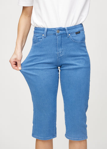 The model stretches the capris at the thigh to show the stretch.