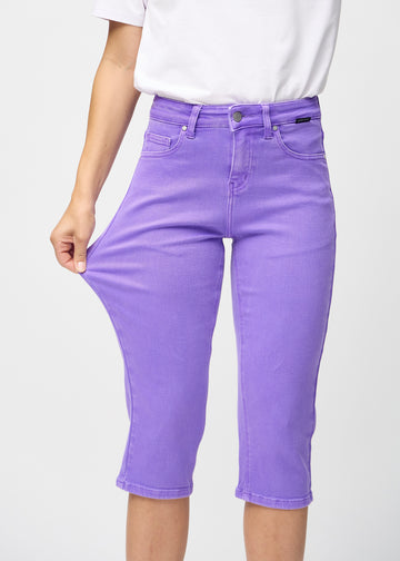 Model stretches the capris at the thigh to show the stretch.