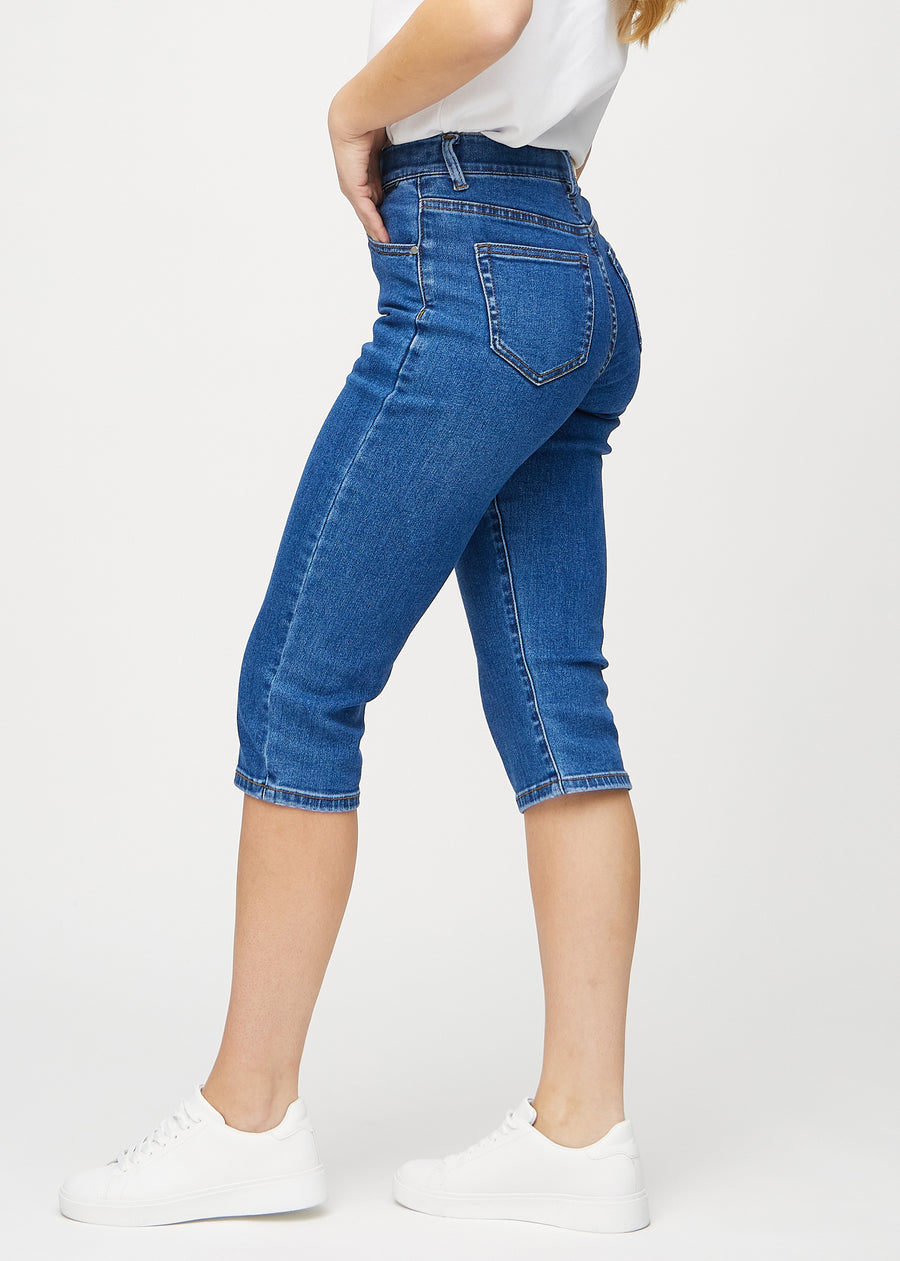 Dark denim regular capris seen from the side on a model.
