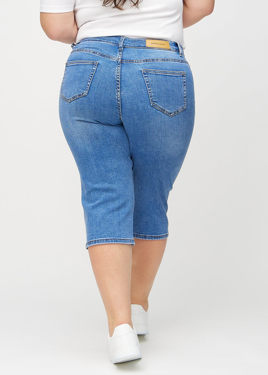 Denim regular capris seen from the back on a plus-size model, so the entire product can be seen.