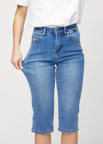 The model stretches the capris at the thigh to show the stretch.