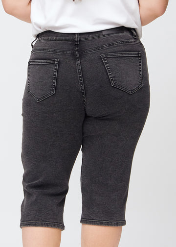 Dark grey denim regular capris seen from the back close up on a plus-size model to show details.