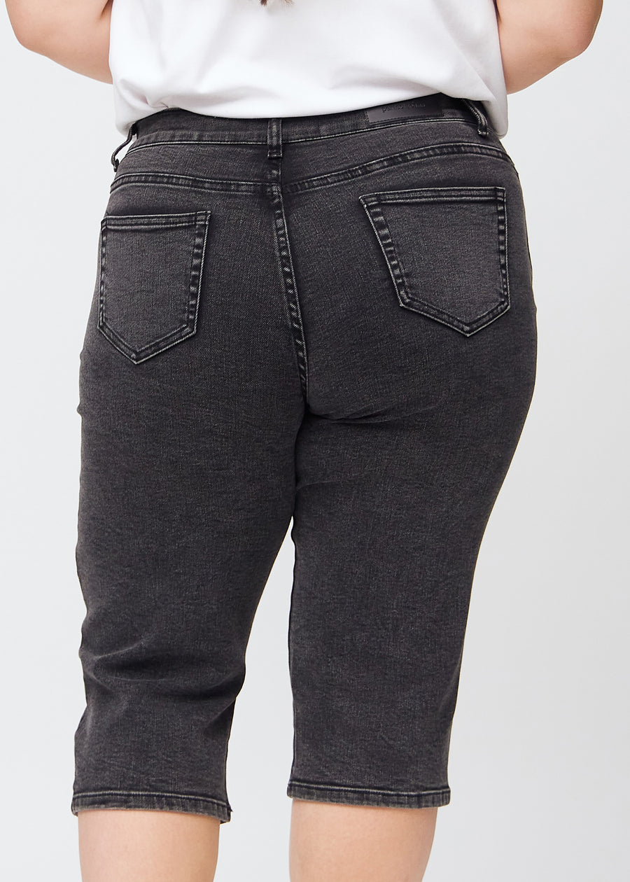 Dark grey denim regular capris seen from the back close up on a plus-size model to show details.