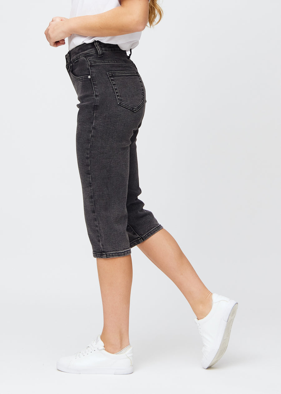 Dark grey denim regular capris seen from the side on a model.