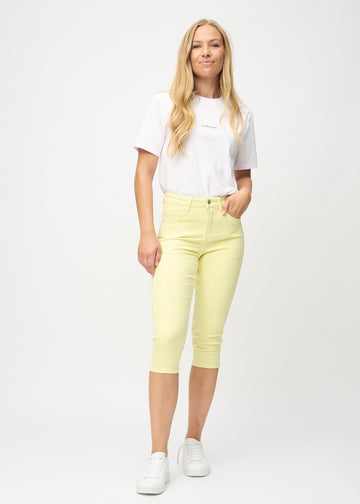 Full-length photo of a model in light yellow Skinny capris in the color Lemonades.