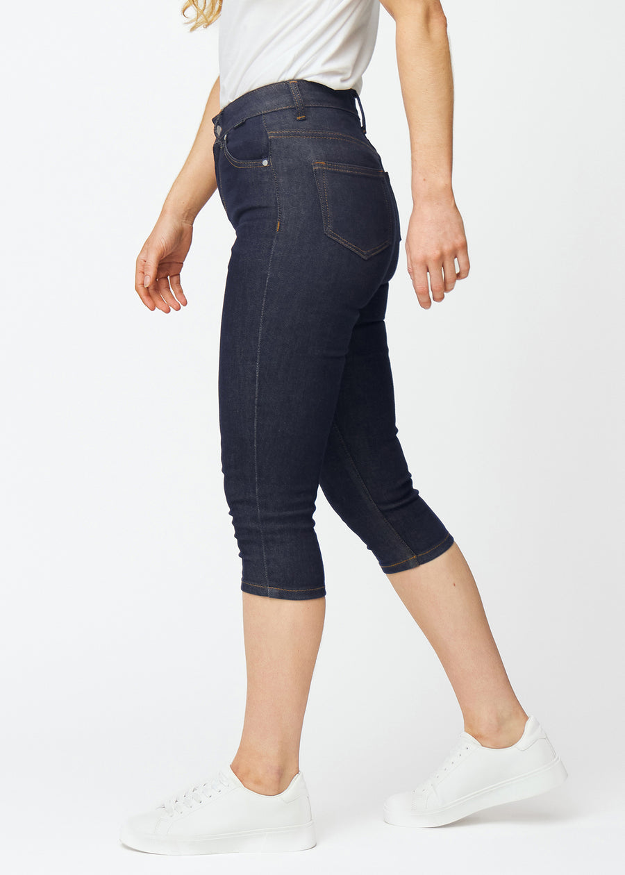 Deep dark blue denim capris for women in the colour Midnights with a skinny fit seen from the side on a model.