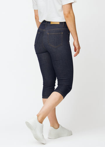 Deep dark blue denim capris for women in the colour Midnights seen from the back, showing the length below the knee.
