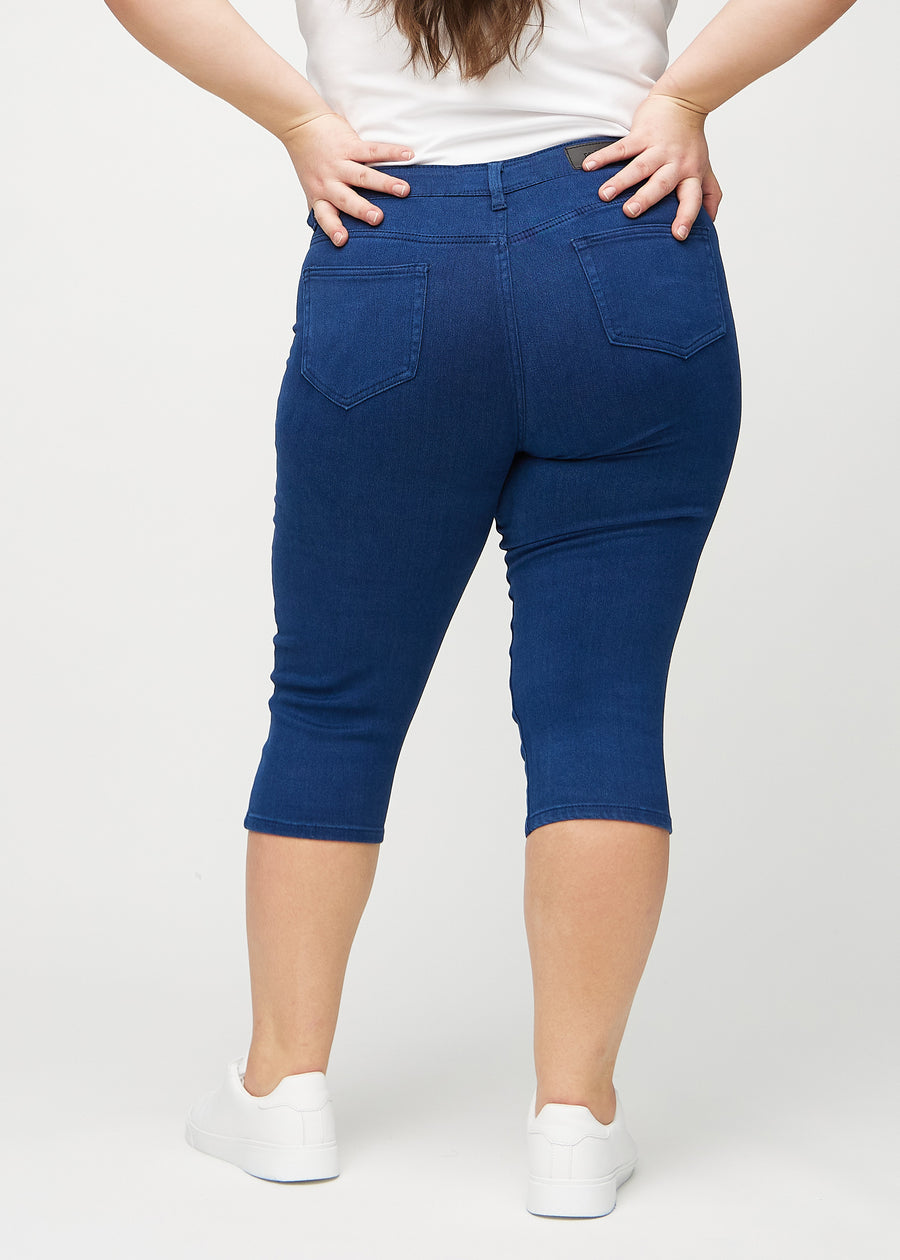 Dark blue skinny capris seen from the back on a plus-size model, so the full product can be seen.