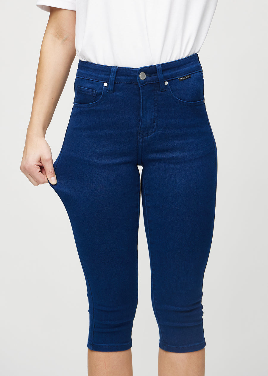 The model stretches the capris at the thigh to show the stretch.