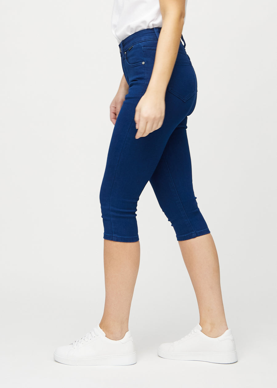 Dark blue skinny capris seen from the side on a model.