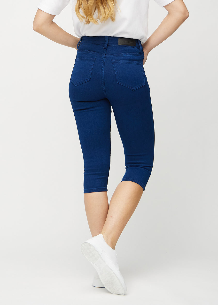 Dark blue skinny capris seen from the back, so the full product can be seen.