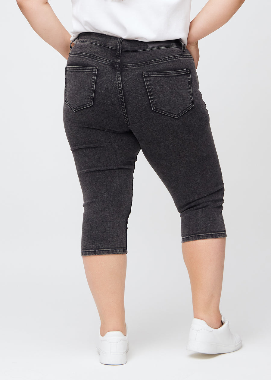 Skinny capris for women in dark grey denim, color Shadows. Back view on a plus-size model, showing the fit and back pockets.