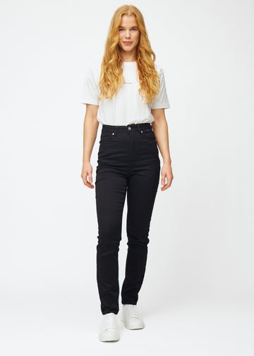 Full image of a model in black high-waisted slim jeans.