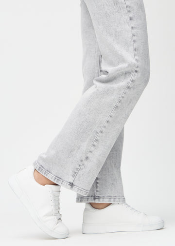 Loose jeans for women in light grey, color Ashes. Close-up at the ankles on a model, showing the wide leg openings.