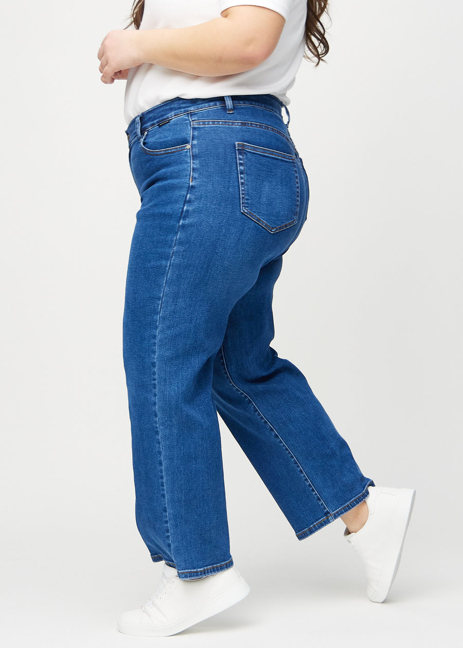 Loose jeans for women in dark blue, color Oceans. Side view on a plus-size model, showing the loose fit.