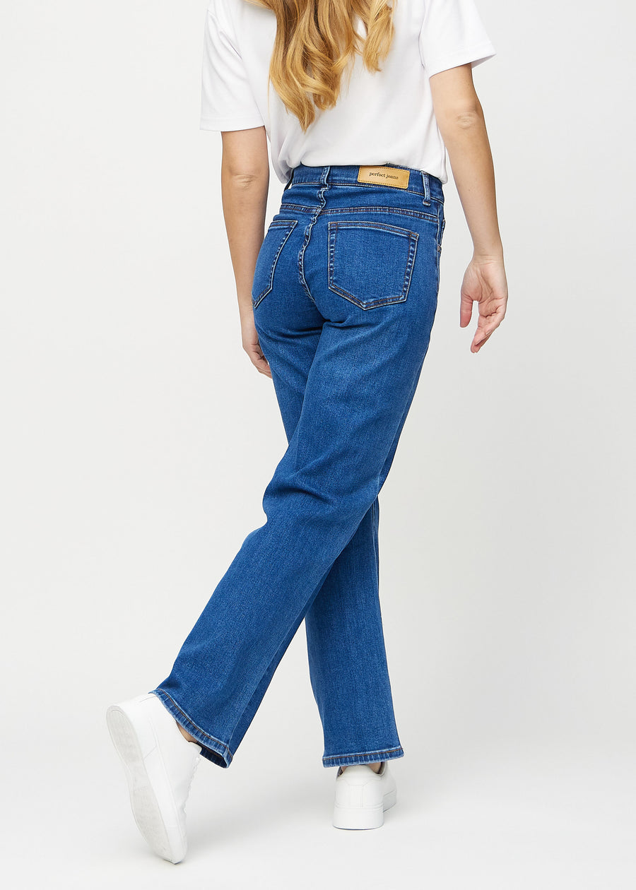 Loose jeans for women in dark blue, color Oceans. Back view on a model, showing the overall relaxed fit.