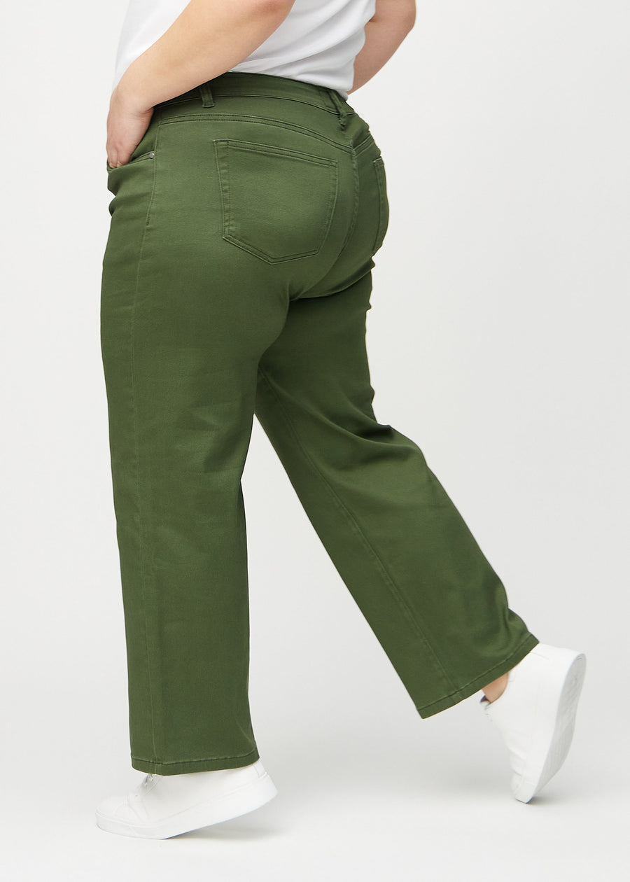 Dark green loose jeans seen from the side on a plus-size model.