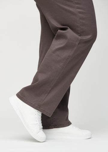 Loose jeans for women in grey-brown, color Thunders. Close-up at the ankles on a plus-size model, showing the wide leg openings.