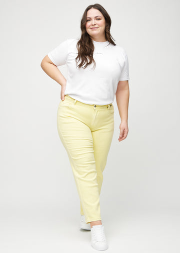 Regular jeans for women in light yellow, color Lemonades. Full-length view of a plus-size model wearing the jeans.