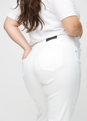 Regular jeans for women in white, color Marguerites. Close-up from behind on a plus-size model, showing fit and details.