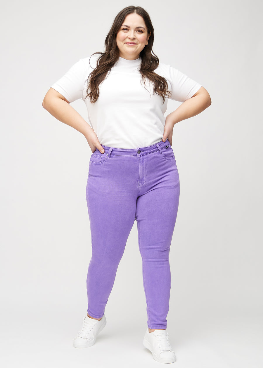 Skinny jeans for women in purple, color Lavenders. Full-length view of a plus-size model in the jeans.
