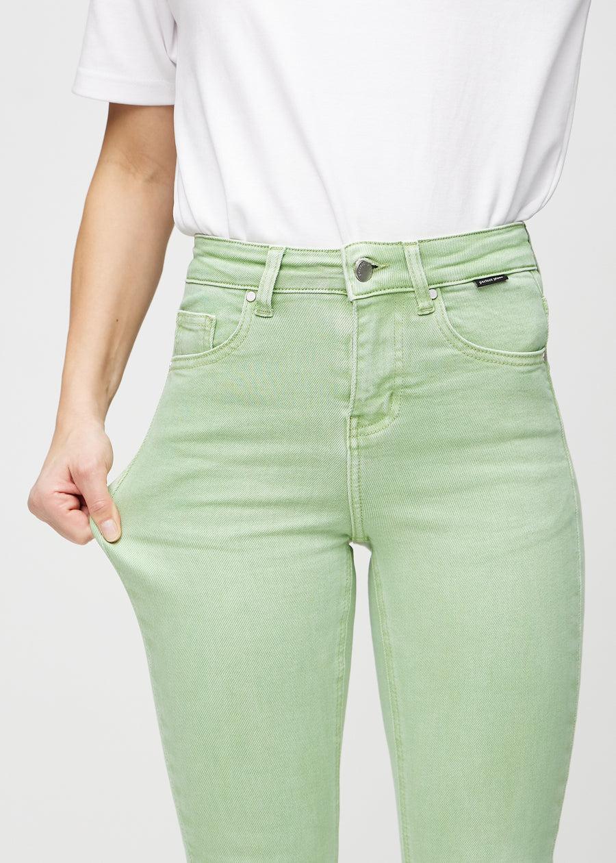 The model stretches the jeans at the thigh to show the stretch.