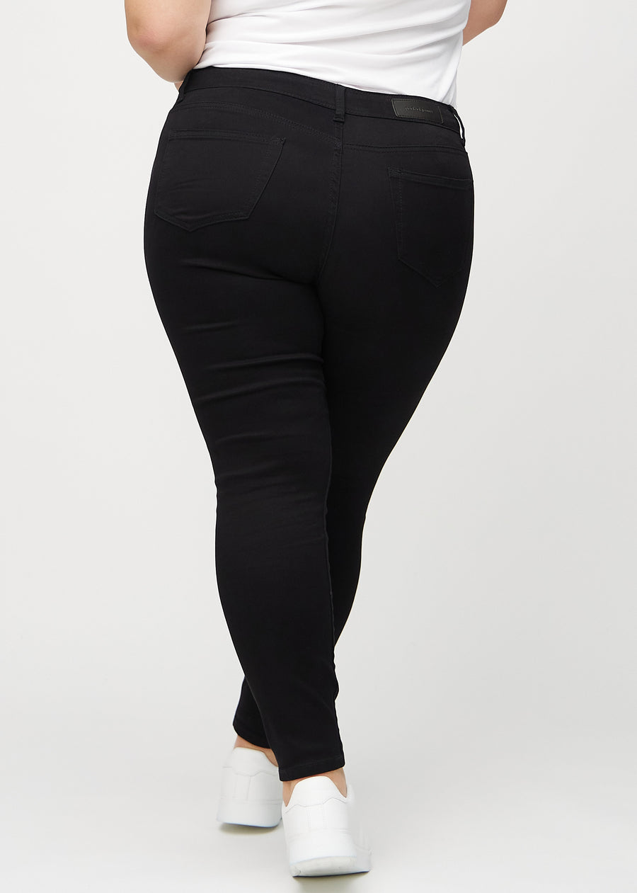 Skinny jeans for women in black, color Ravens. Back view on a plus-size model, showing the overall fit.