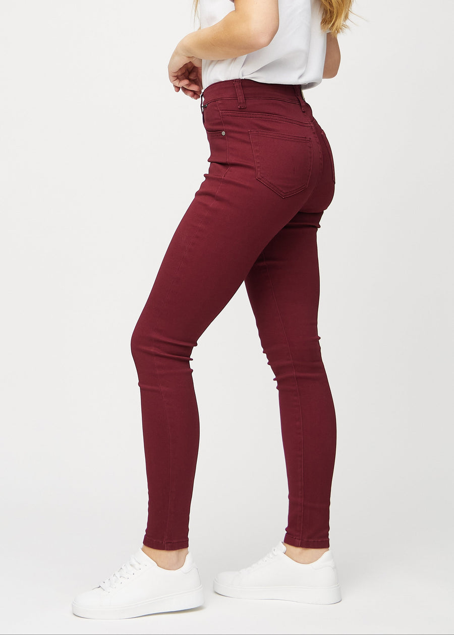 Skinny jeans for women in dark red, color Santas. Side view on a model.
