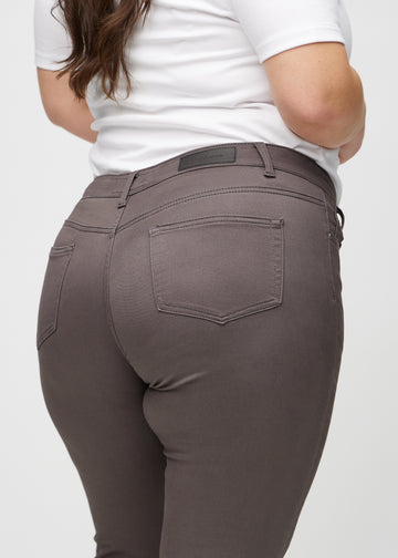 Skinny jeans for women in grey brown, color Thunders. Close-up back view on a plus-size model, showing details.