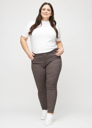 Skinny jeans for women in grey brown, color Thunders. Full-length view of a plus-size model in the jeans.