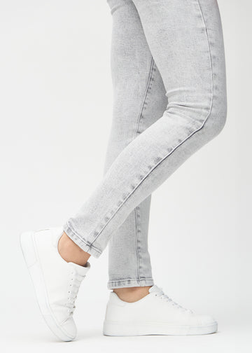 Slim jeans for women in light grey, color Ashes. Close-up at the ankles on a model, showing the fit at the leg openings.