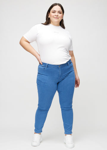 Slim jeans for women in blue, color Geraniums. Full-length view of a plus-size model wearing the jeans.