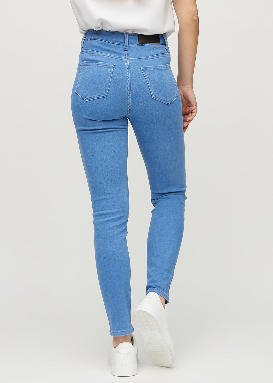 Slim jeans for women in blue, color Geraniums. Back view on a model, showing the overall fit.
