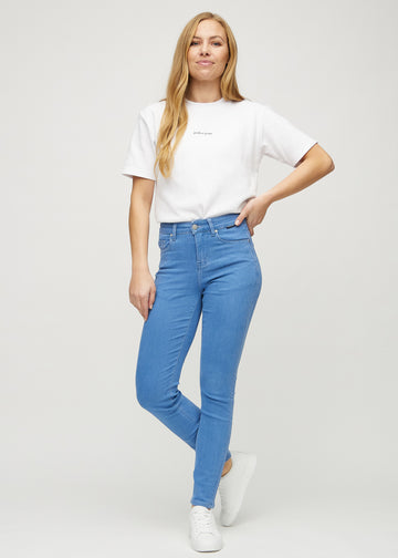 Slim jeans for women in blue, color Geraniums. Full-length view of a model wearing the jeans.