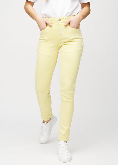 Slim jeans for women in light yellow, color Lemonades. Front view on a model, showing a close fit through the leg with a little more room at the ankle.