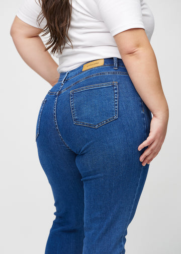 Slim jeans for women in dark blue, color Oceans. Close-up back view on a plus-size model, showing the details.