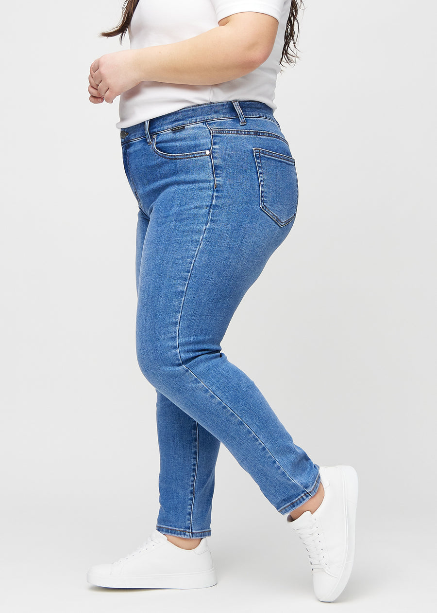 Slim jeans for women in blue, color Rivers. Side view on a plus-size model.