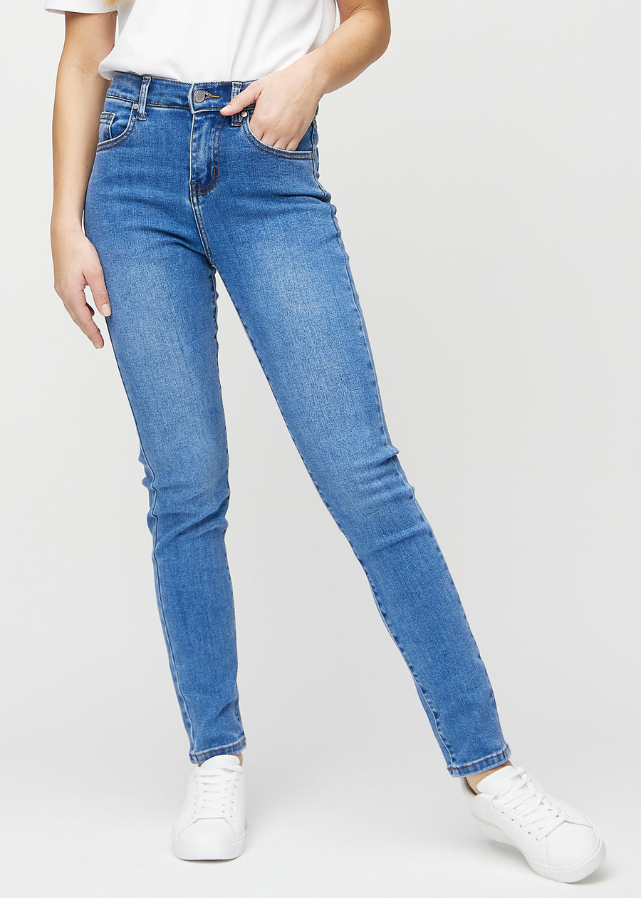 Slim jeans for women in blue, color Rivers. Front view on a model, showing a close fit through the leg with a little more room at the ankle.